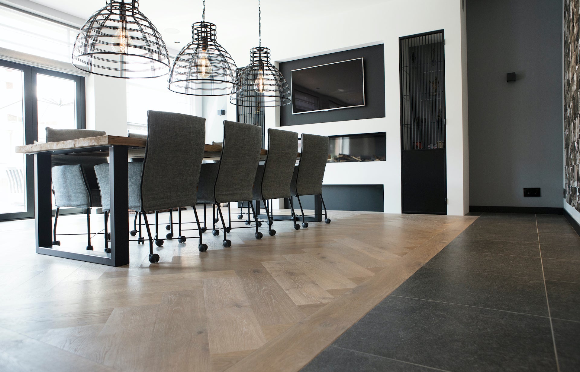 Lichtbruine visgraatvloer in een stijlvolle eetkamer, geplaatst door Bosman Houten Vloeren