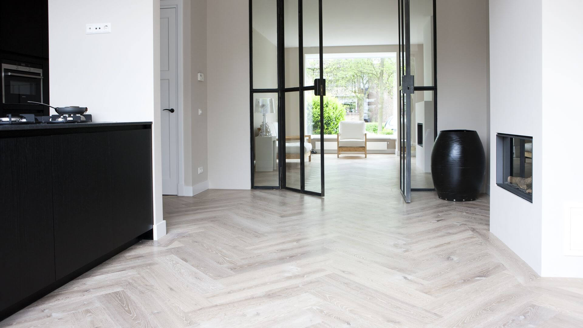 Visgraat vloer met band in een moderne woonkamer met een zwarte keuken voor een stijlvol contrast
