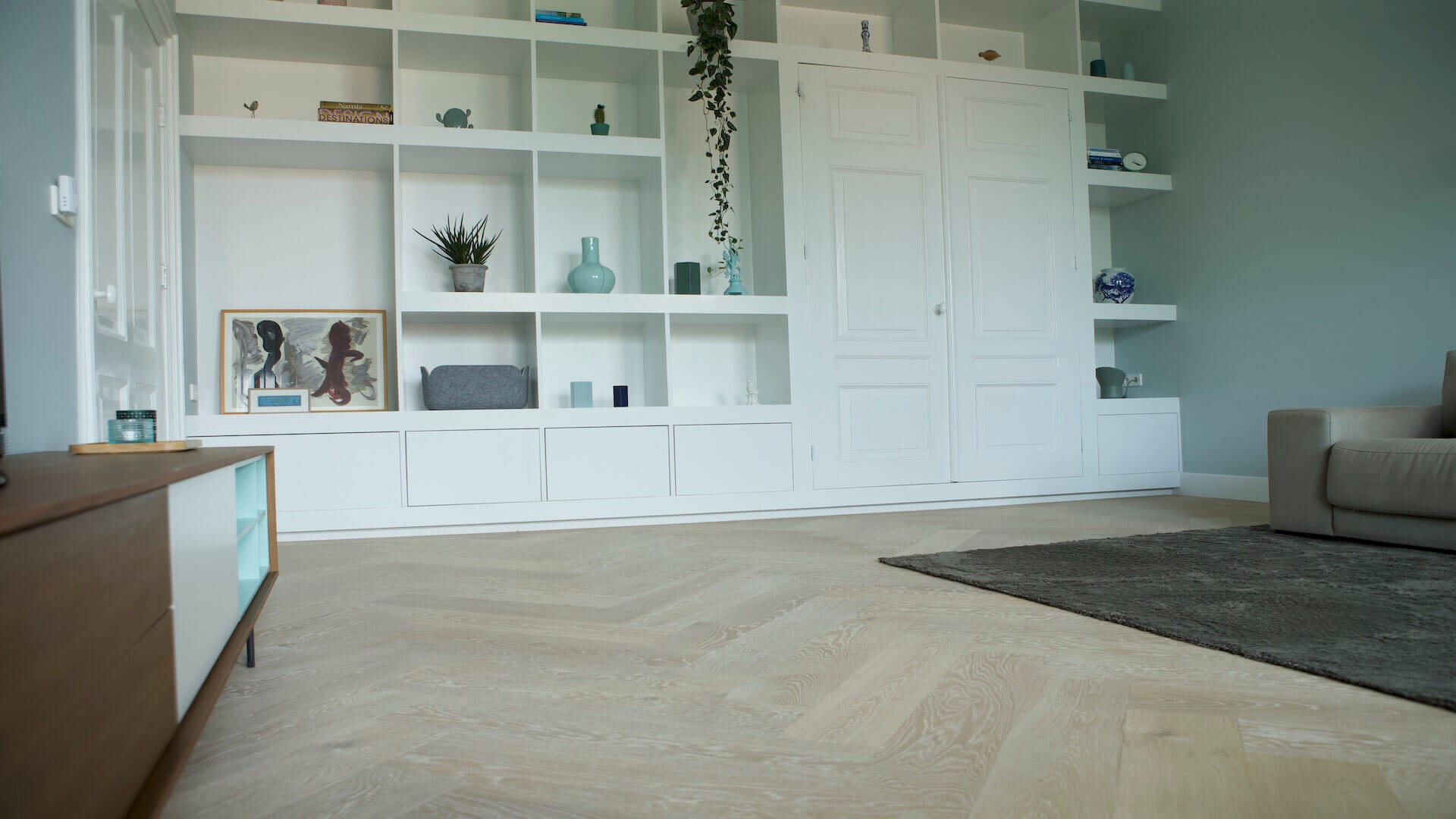 Woonkamer met een witte visgraat vloer voor een lichte en elegante uitstraling
